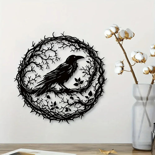 Round black crow wall art on a white wall beside a vase