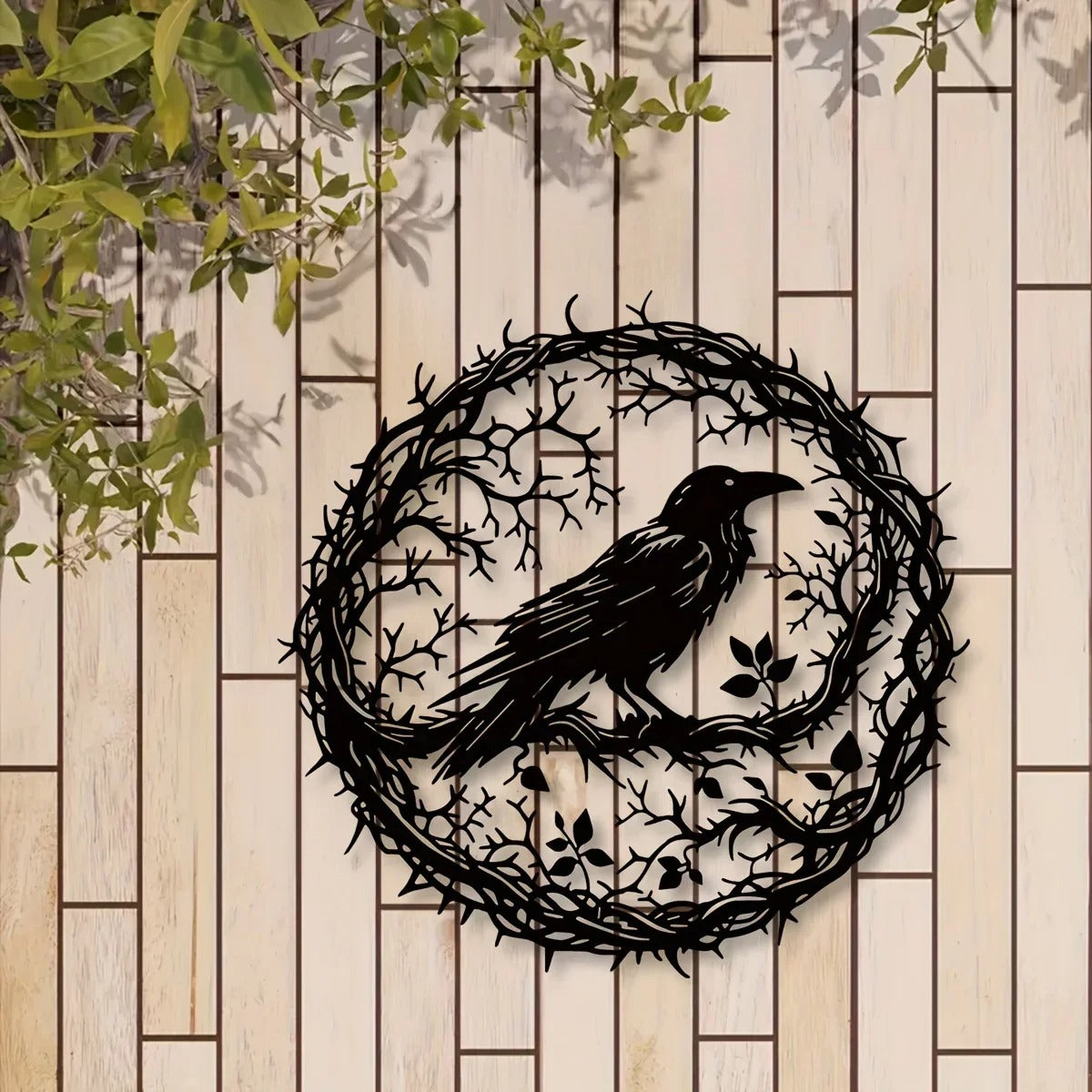 Round crow wall art on a wooden fence