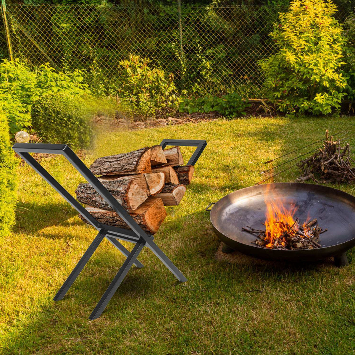 Black steel firewood rack with logs on a lawn next to an outdoor fire pit