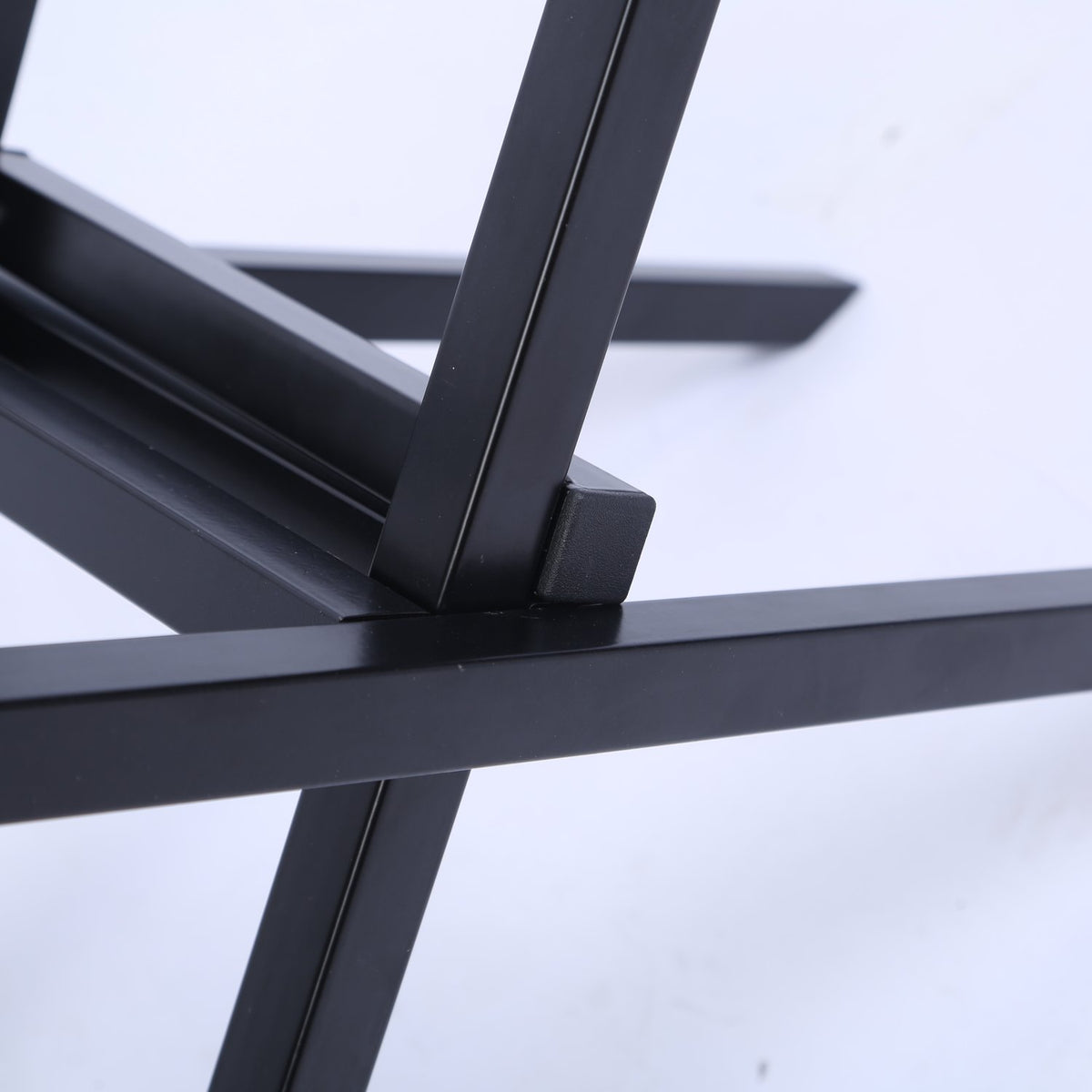 Close-up of the folding joint on the black steel firewood rack